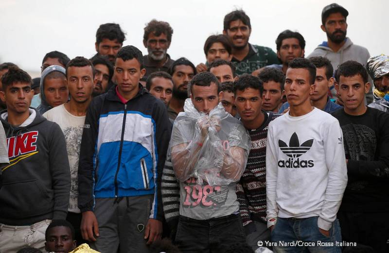 Migranti attendono il completamento delle operazioni di sbarco. Foto: Yara Nardi - Croce Rossa Italiana