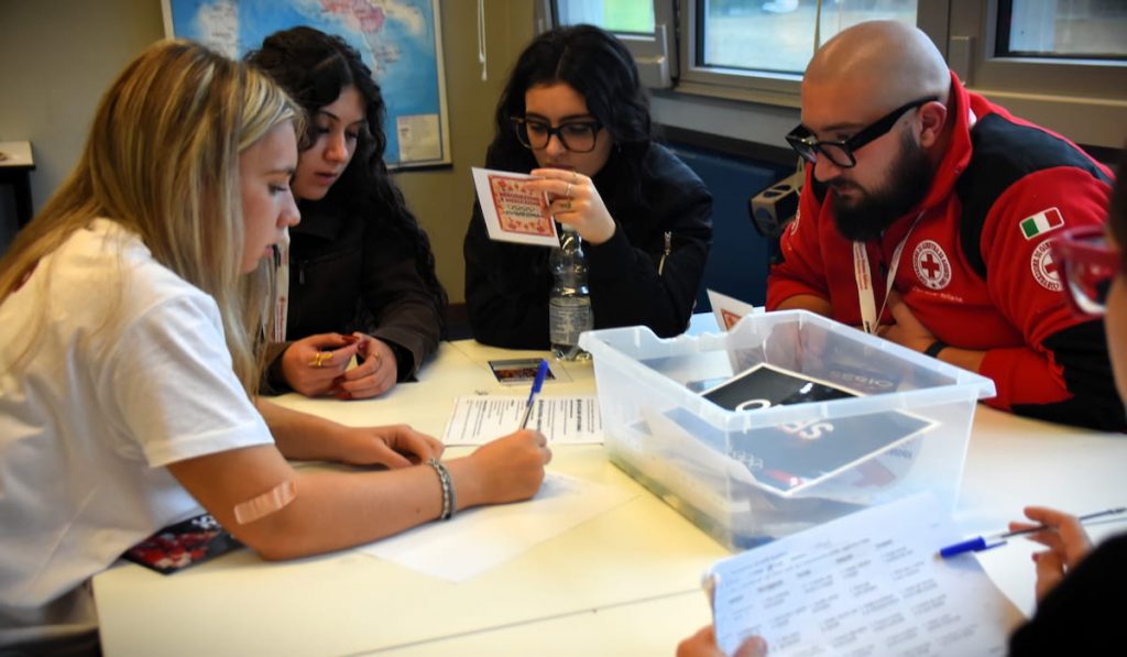 Partecipanti alle Lombardiadi 2026 collaborano attorno a un tavolo durante un'attività di squadra.