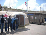 Migranti entrano nella tenda che ospita il Posto Medico Avanzato