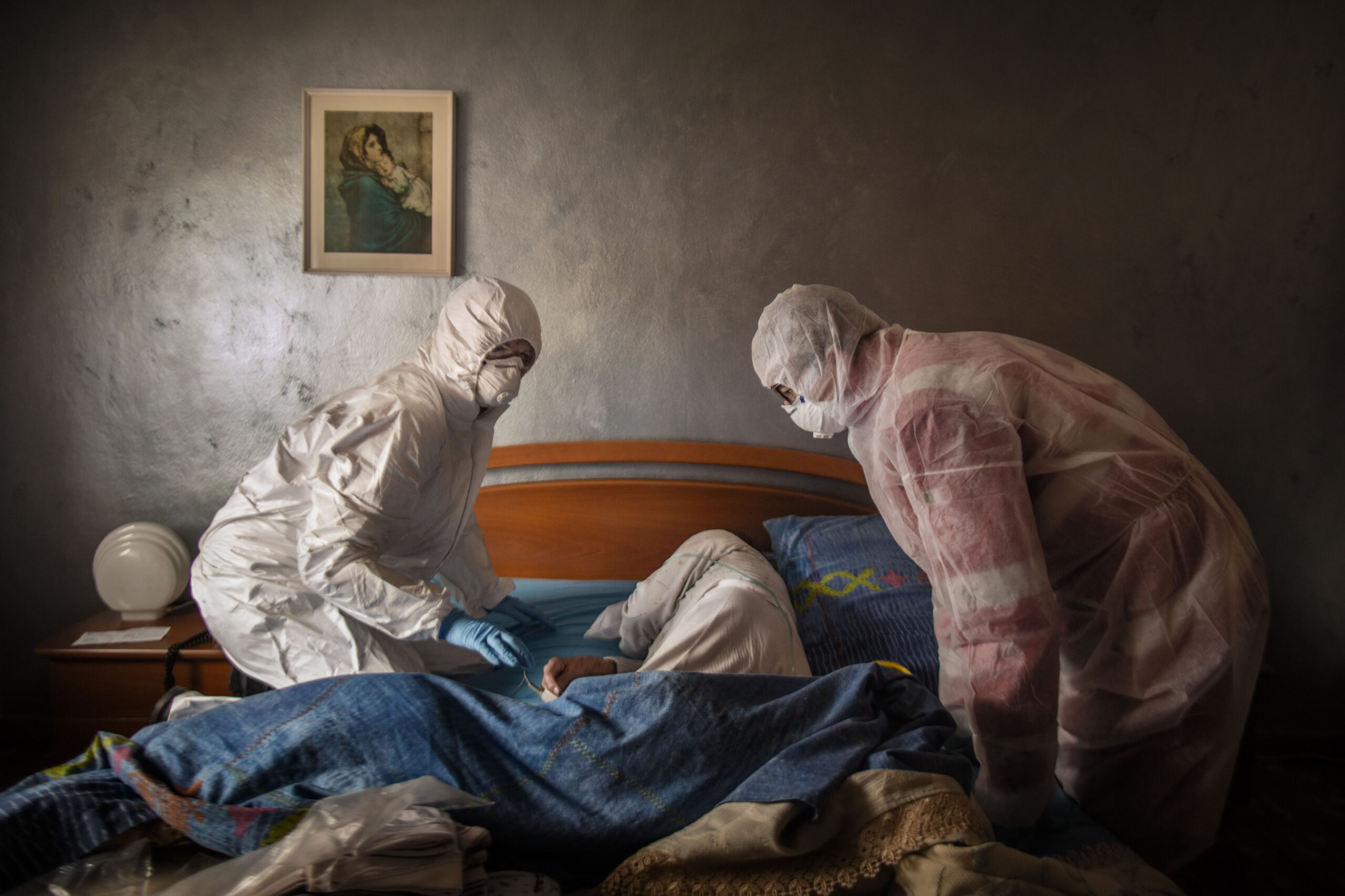 Fabio Bucciarelli -
Pradalunga (Bergamo), Marzo 2020.  
Volontari della Croce Rossa visitano una paziente sospettata di aver contratto il COVID-19, mentre è stesa, quasi incosciente, sul letto.