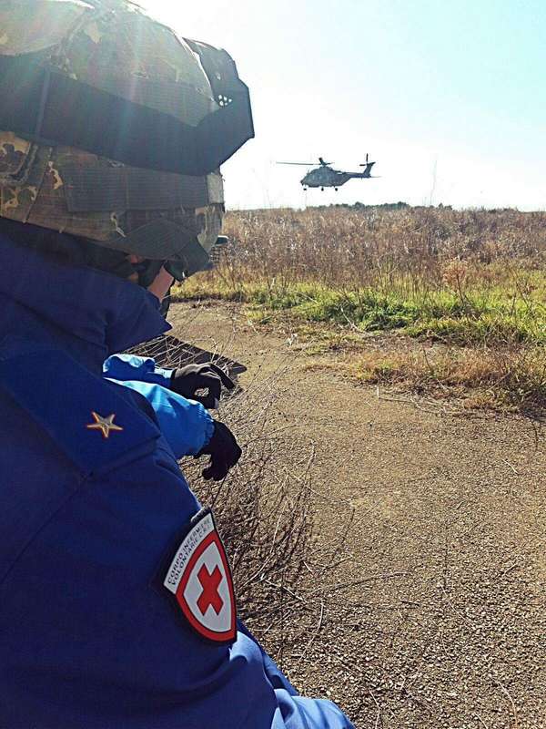 Un'Infermiera Volontaria CRI osserva l'elicottero che si muove all'orizzonte