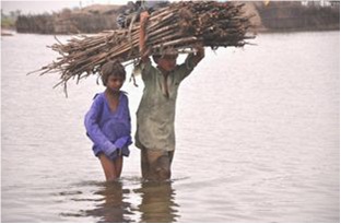 Due bambini nell'acqua portano della legna