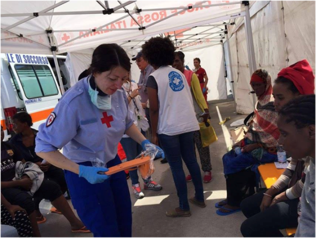 Infermiera Volontaria CRI impegnata nella prima assistenza ai migranti appena sbarcati.
