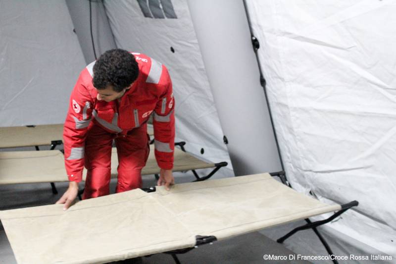 Volontario Croce Rossa monta una brandina nel centro allestito per accogliere le vittime del sisma. Foto: Marco Di Francesco, Croce Rossa Italiana