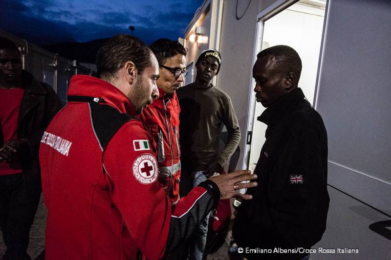 Campo Roya di Ventimiglia operatori e volontari Croce Rossa parlano a un migrante in transito, il ragazzo sembra molto triste