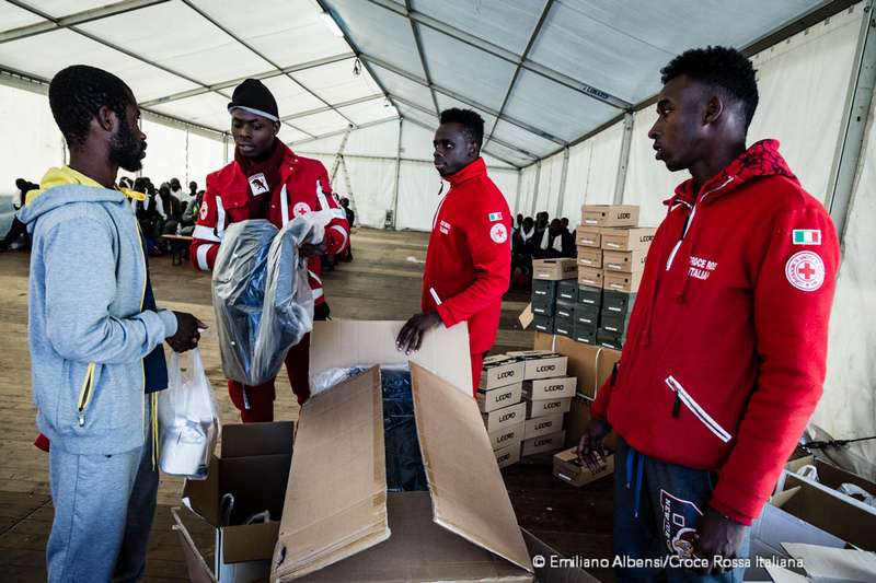 Volontari Croce Rossa distribuiscono vestiti ai ragazzi migranti che arrivano al Centro Fenoglio di Settimo Torinese