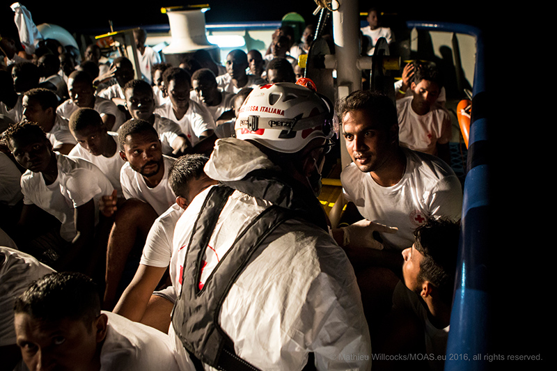 MIGRANTI: operazione MOAS CRI migranti chiedono informazioni a un operatore di Croce Rossa Italiana © Mathieu Willcocks/MOAS.eu 2016, tutti i diritti riservati