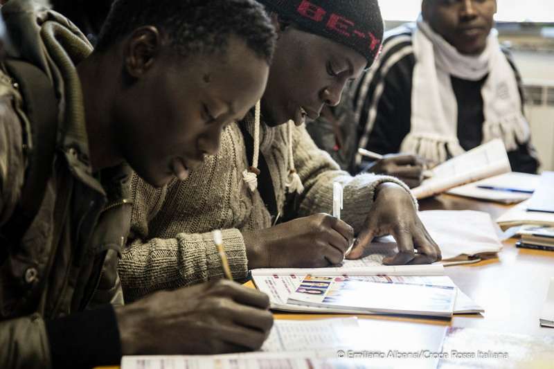 Al centro di accoglienza migranti della Croce Rossa a Bresso i ragazi concentrati prendono appunti durante la lezione di italiano