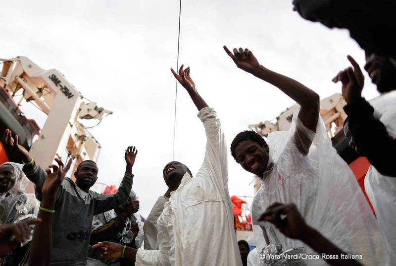 Migranti cantano felici al termine del lungo viaggio che li ha portati in Italia. Foto: Yara Nardi - Croce Rossa Italiana