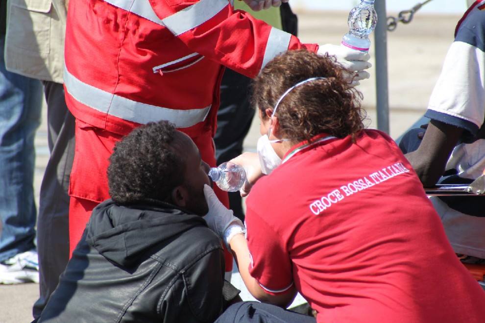 Volontari soccorrono migrnati a Taranto