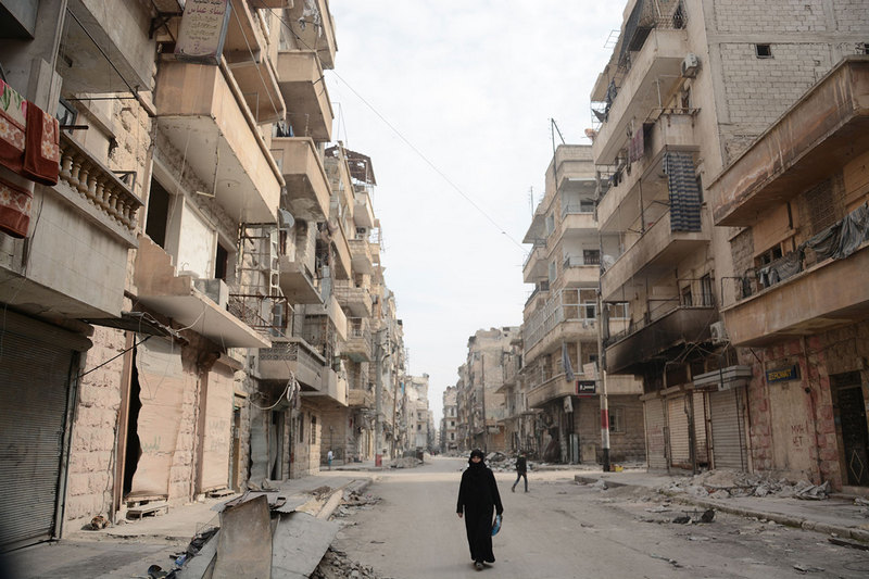 Una donna cammina ad Aleppo, città martoriata dalla guerra