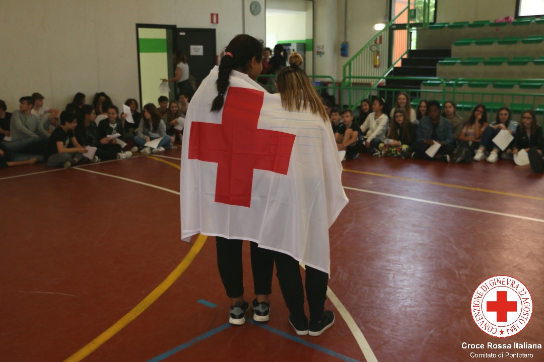 Alcuni ragazzi con la bandiera della Croce Rossa donata alla scuola