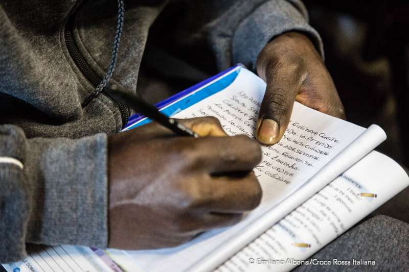Al  centro di accoglienza migranti della Croce Rossa a Bresso un ragazzo prende appunti durante la lezione di italiano