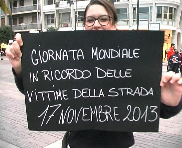 Volontario con cartello "Giornata mondiale in ricordo delle vittime della strada 17.11.2013"