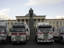 Automezzi della CRI parcheggiati sotto la statua di Stalin, nella piazza centrale di Gori