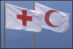 Fotografia di due bandiere di Croce Rossa e Mezzaluna Rossa che sventolano