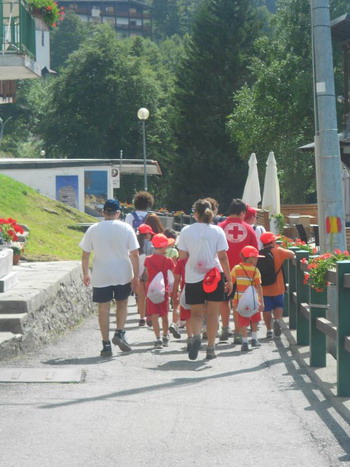 Bamini passeggiano con volontari croce rossa