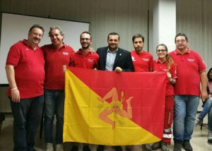 Il momento in cui il presidente regionale della CRI Luigi Corsaro consegna la bandiera della Sicilia