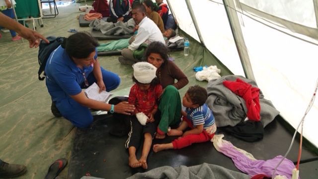 Pazienti evacuati fuori dall'ospedale di Bidur, in attesa di assistenza presso la tenda ospedale italiana.