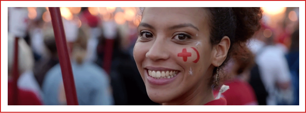 Il sorriso di una volontaria di Croce Rossa e Mezzaluna Rossa durante la fiaccolata di Solferino